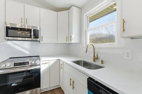 a kitchen with stainless steel appliances granite countertop a sink and a stove