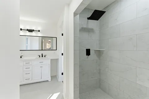 a bathroom with a bathtub sink vanity and mirror