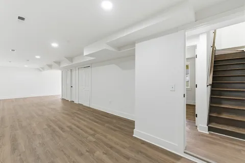 a view of a hallway with wooden floor and entryway