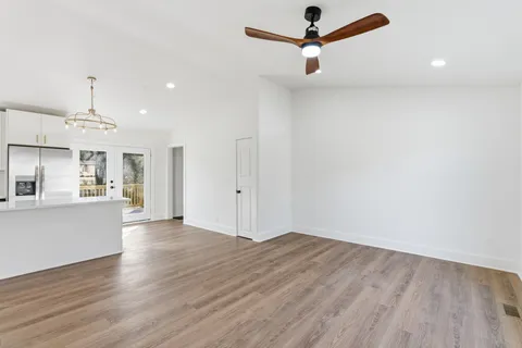 a view of a kitchen with wooden floor a ceiling fan and wooden floor