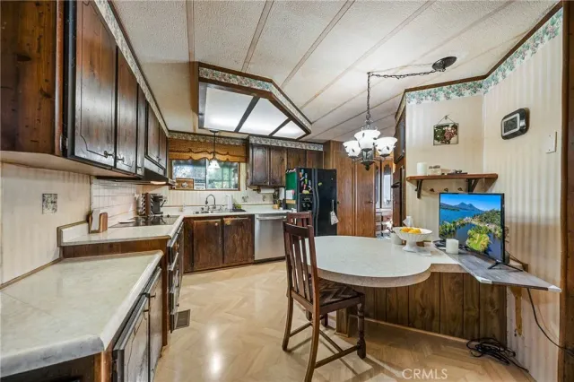 a kitchen with stainless steel appliances granite countertop a sink a stove and chairs