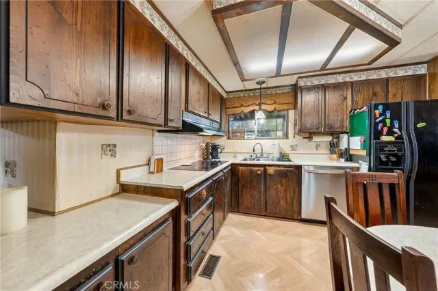a kitchen with stainless steel appliances granite countertop a sink a stove and cabinets