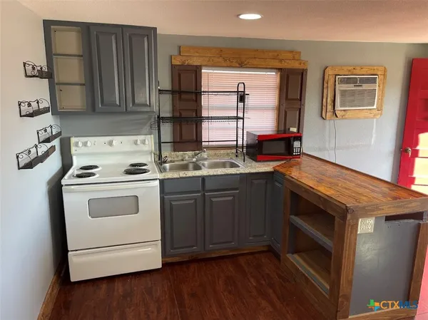 a kitchen with a stove a sink and a microwave