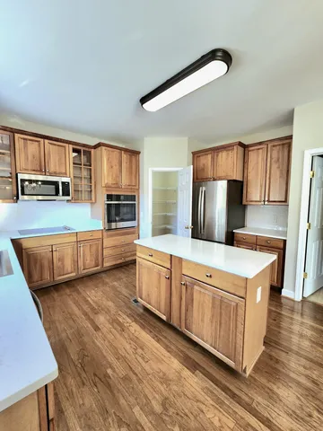 a kitchen with stainless steel appliances granite countertop a stove a sink and a refrigerator