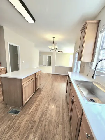 a kitchen with a sink and wooden floor