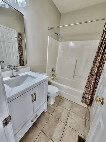 a bathroom with a granite countertop sink a toilet and shower
