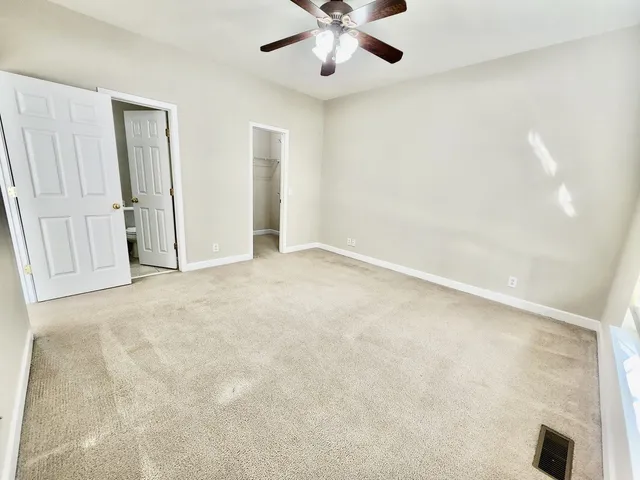 an empty room with fan and windows