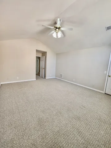 an empty room with windows and chandelier fan