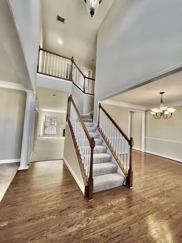 a view of staircase with white walls and a fan