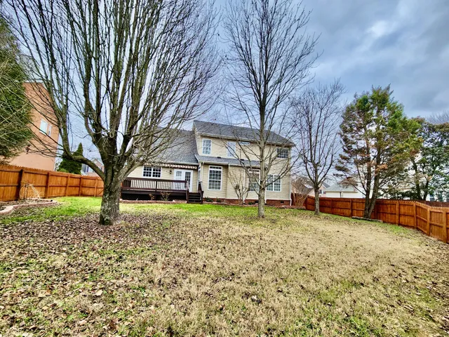 a view of a yard with a wooden fence