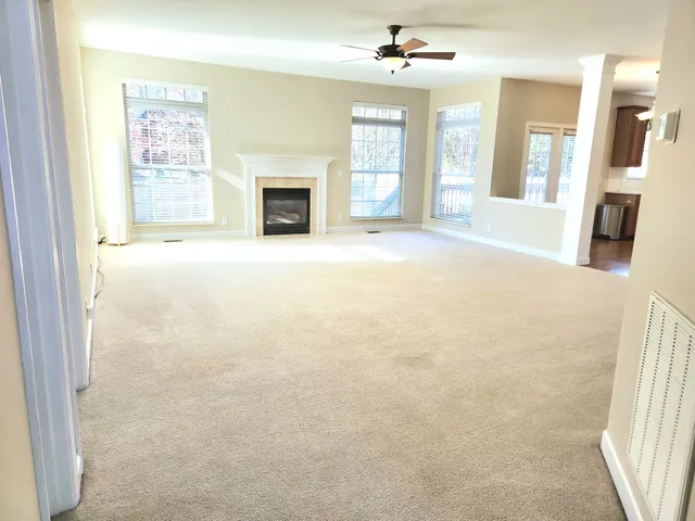 a view of an empty room with a fireplace and a window