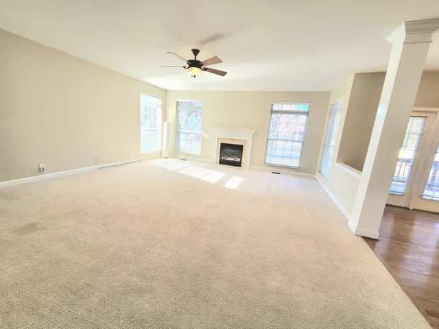 a view of an empty room with a fireplace and a window