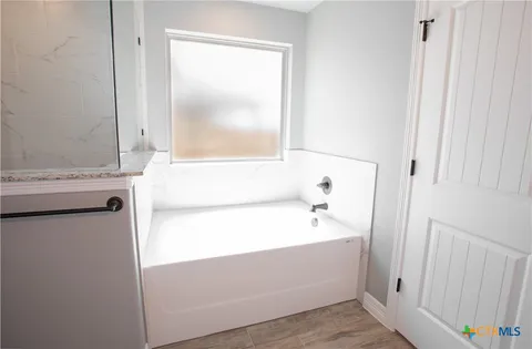 a bathroom with a bathtub and a window