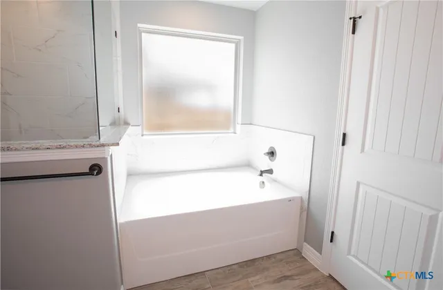a bathroom with a bathtub and a window