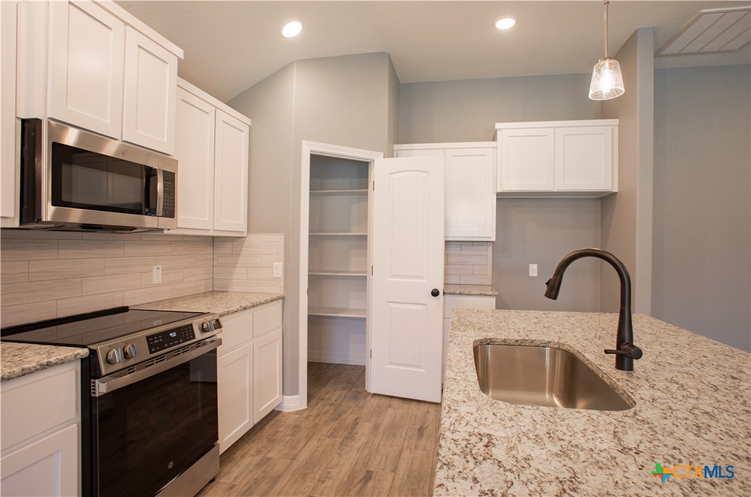 3221 Digby Drive Belton, TX 76513 - Photo 4 of 30 a kitchen with granite countertop a sink stainless steel appliances and cabinets