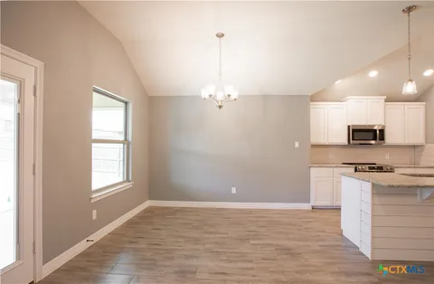 a view of a kitchen with a stove cabinets and wooden floor