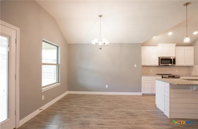 a view of a kitchen with a stove cabinets and wooden floor