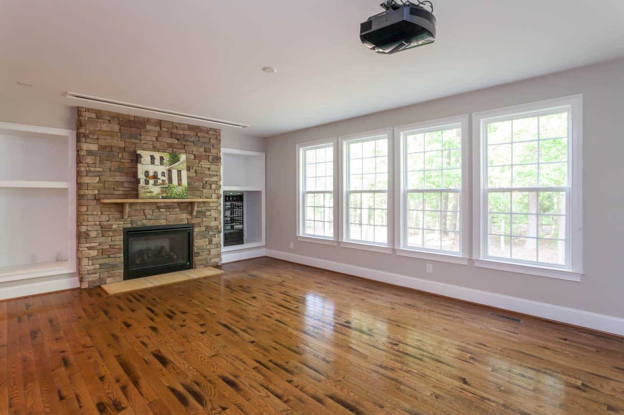 8915 Scotch Castle Drive Raleigh, NC 27612 - Photo 4 of 25 The family room is open to the kitchen and features a large set of bookcases that frame the stone fireplace AND it is fully wired for surround sound and features a drop down state of the art movie screen that is operated by a toggle switch on the wall. Family Room and Media Room