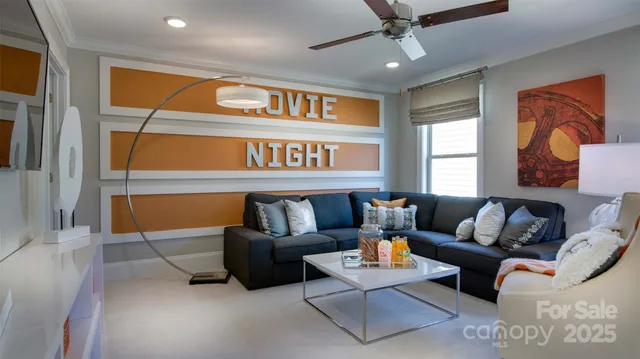 a living room with furniture a ceiling fan and a window