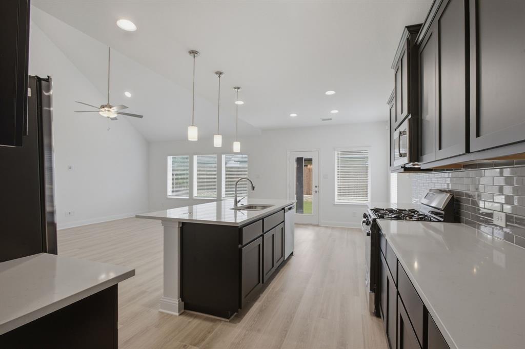 2911 Hanscom Street Forney, TX 75126 - Photo 4 of 40 Modern kitchen featuring dark cabinetry, light countertops, and a subway tile backsplash