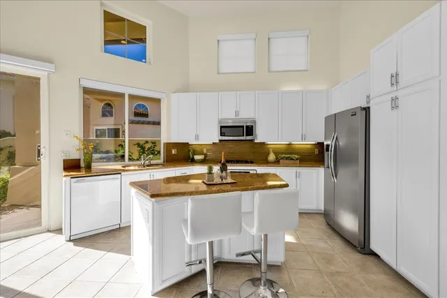 a kitchen with stainless steel appliances granite countertop a sink and a refrigerator