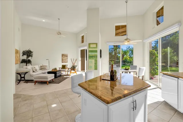 a living room with patio furniture and floor to ceiling windows