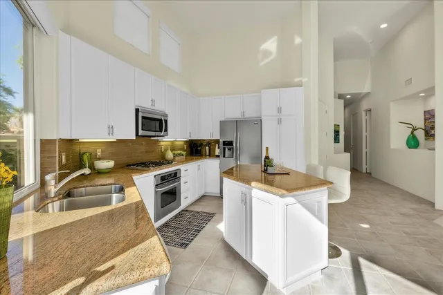 a kitchen with granite countertop a sink stove and refrigerator