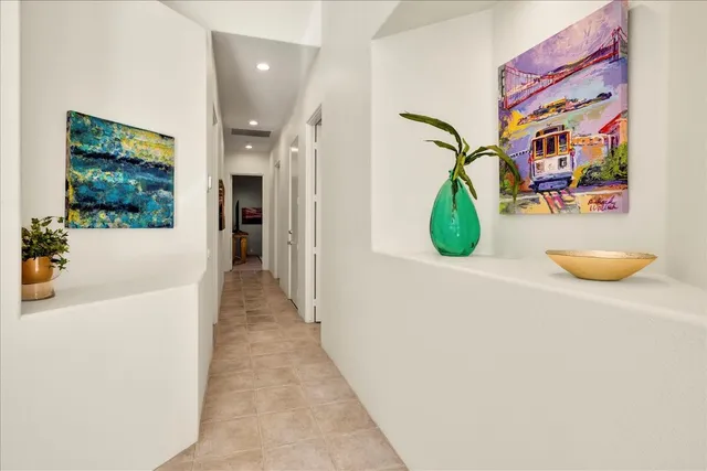 a spacious bedroom with a bed and a chandelier