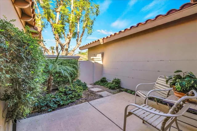 a view of patio with a table and chairs and potted plants