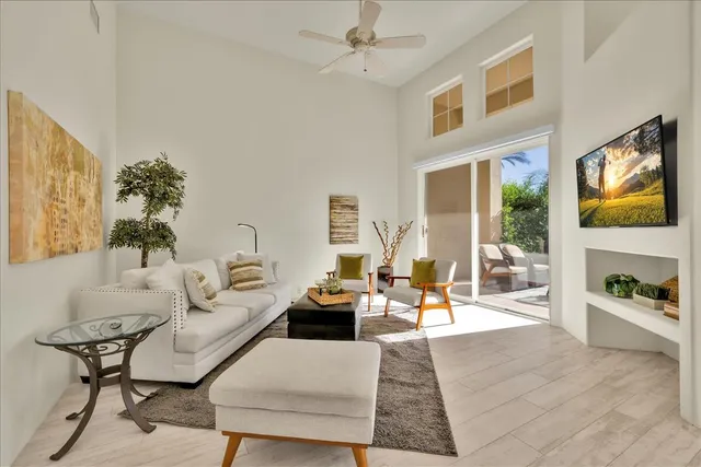 a living room with furniture large window and flat screen tv