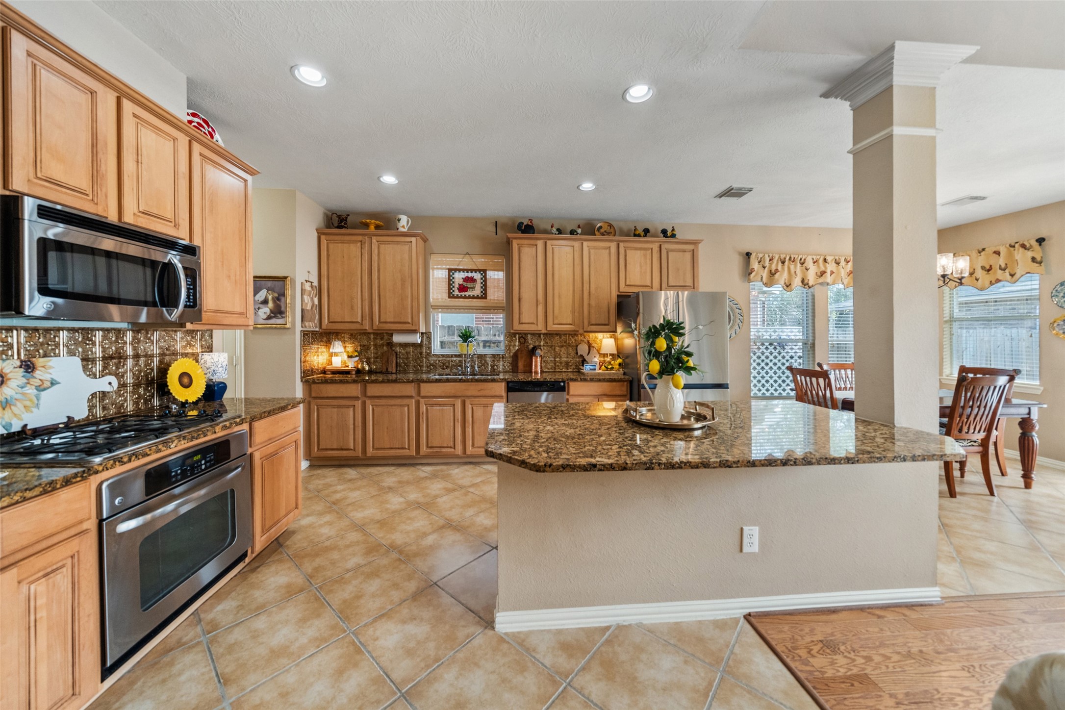 14422 Andrews Ridge Lane Humble, TX 77396 - Photo 4 of 40 a large kitchen with stainless steel appliances granite countertop a stove a sink and a microwave