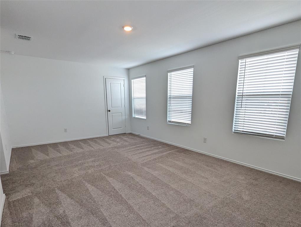 152 Avre Loop Kyle, TX 78640 - Photo 14 of 24 A spacious room offers plush carpet and ample natural illumination through multiple windows.