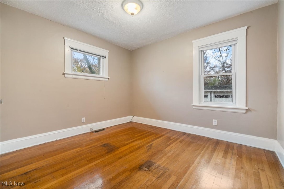 4488 Rainbow Road Cleveland, OH 44121 - Photo 23 of 39 Empty room with hardwood / wood-style floors and a textured ceiling