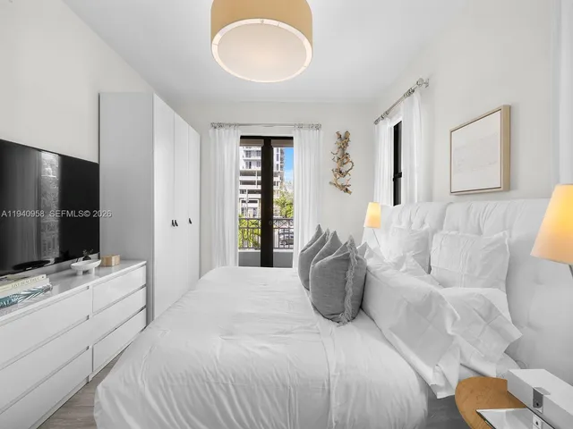 a spacious bedroom with a bed and a flat screen tv