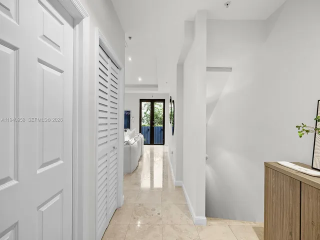 a view of a hallway with white walls and stairs