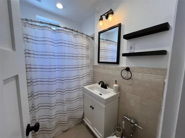 a bathroom with a sink a toilet and shower curtain