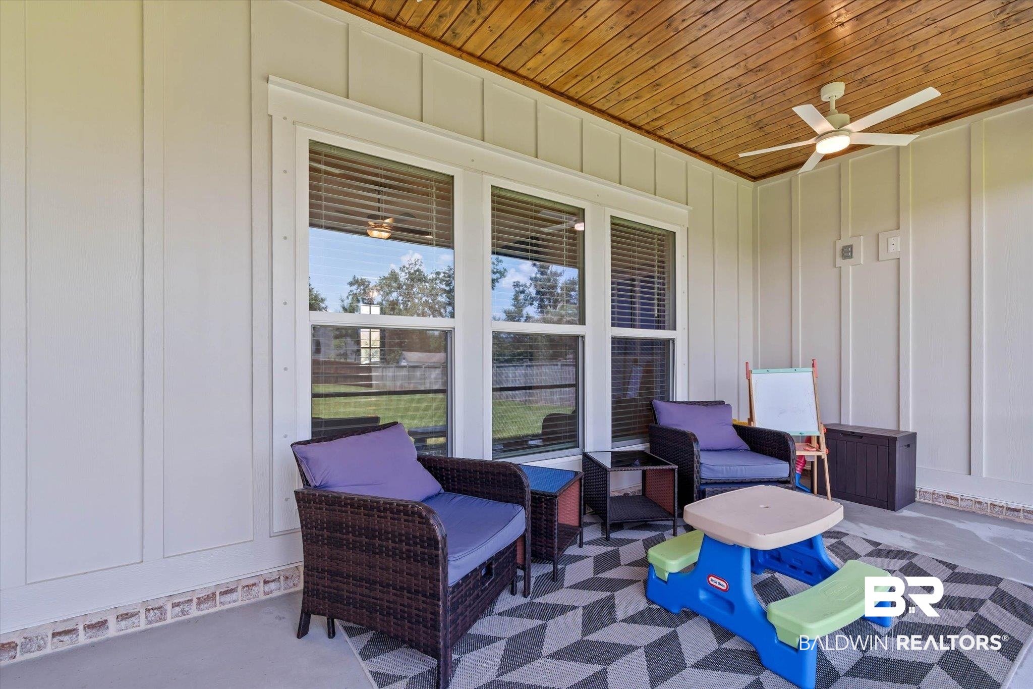 23523 Travis Stock Street Foley, AL 36535 - Photo 28 of 45 Covered patio featuring a wood-finish ceiling, board-and-batten style wall paneling, and a ceiling fan with integrated lighting