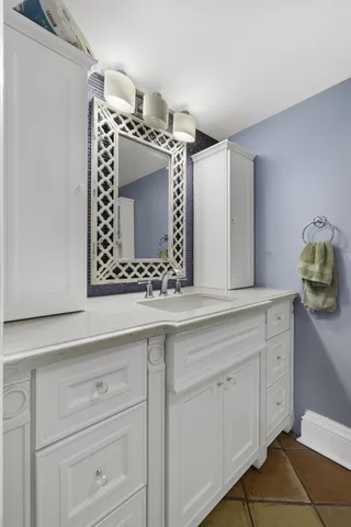 a bathroom with a sink vanity and mirror