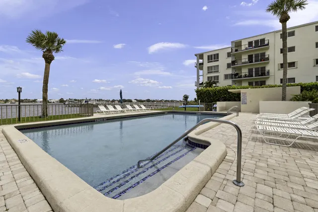 a view of swimming pool with outdoor seating and a buildings in the background