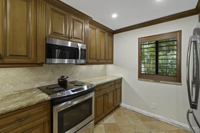 a kitchen with stainless steel appliances granite countertop a stove a microwave and cabinets