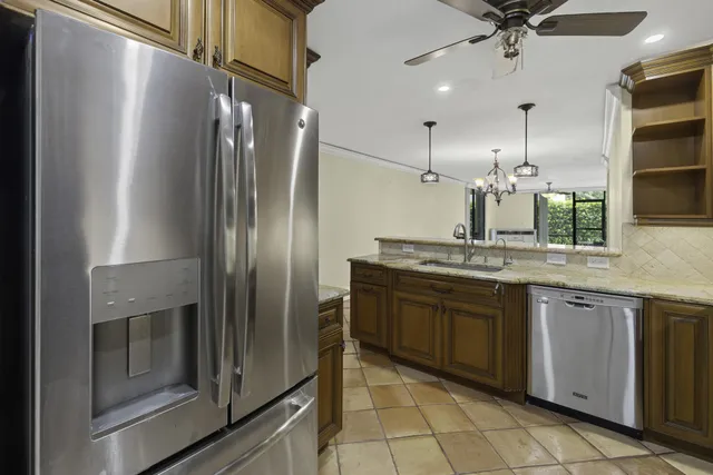a kitchen with stainless steel appliances granite countertop a refrigerator and a sink