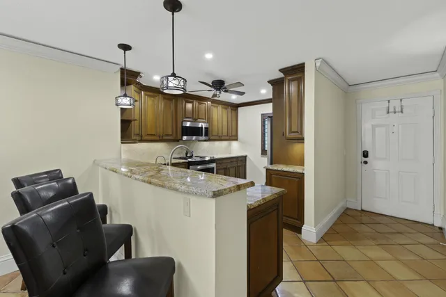 a kitchen with stainless steel appliances granite countertop a sink refrigerator and cabinets