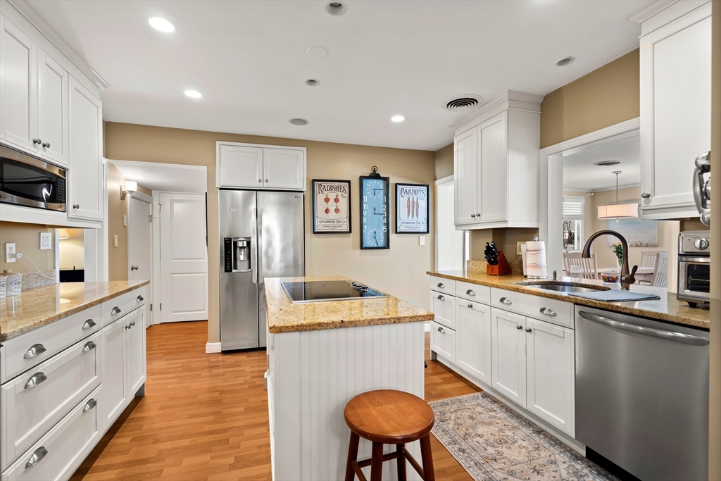 4 Dean Road Marblehead, MA 01945 - Photo 7 of 38 a kitchen with stainless steel appliances granite countertop a refrigerator a sink dishwasher a stove and white cabinets with wooden floor