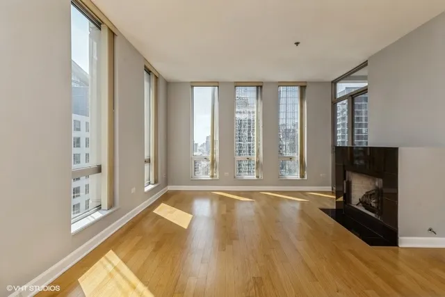 a view of empty room with wooden floor and fireplace