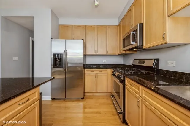 a kitchen with stainless steel appliances granite countertop a stove a refrigerator and a sink