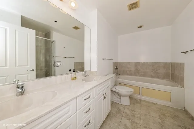 a bathroom with a double vanity sink toilet and shower