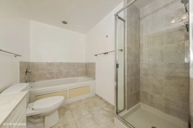 a bathroom with a granite countertop toilet a sink and shower