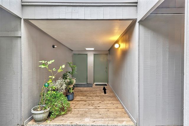 a view of a hallway with wooden floor and a potted plant
