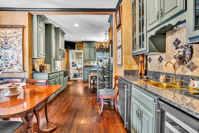 a kitchen with stainless steel appliances granite countertop a stove and a dining table next to a window