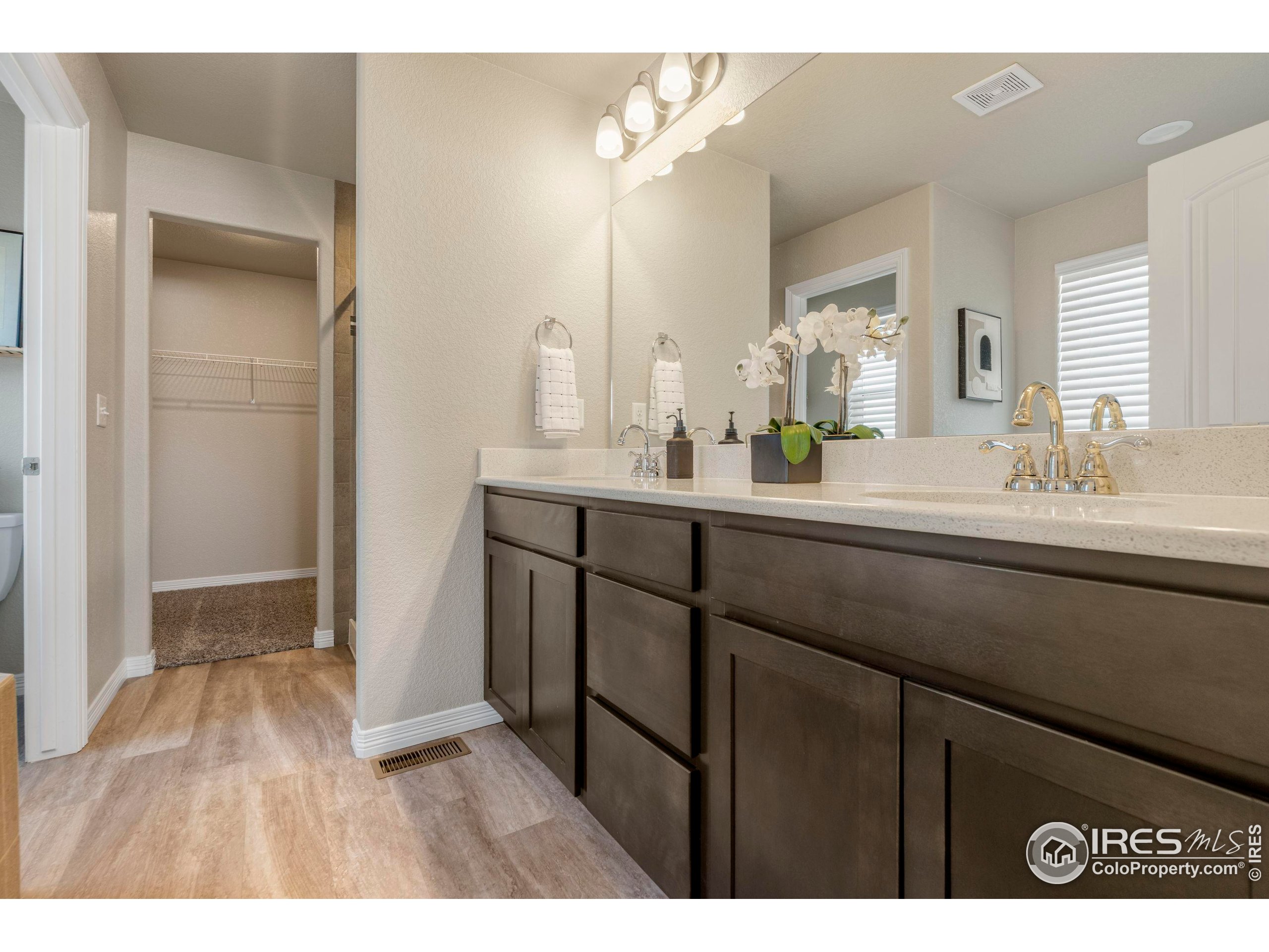 4527 Longmead Drive Windsor, CO 80550 - Photo 19 of 32 a en suite bathroom with a sink mirror and